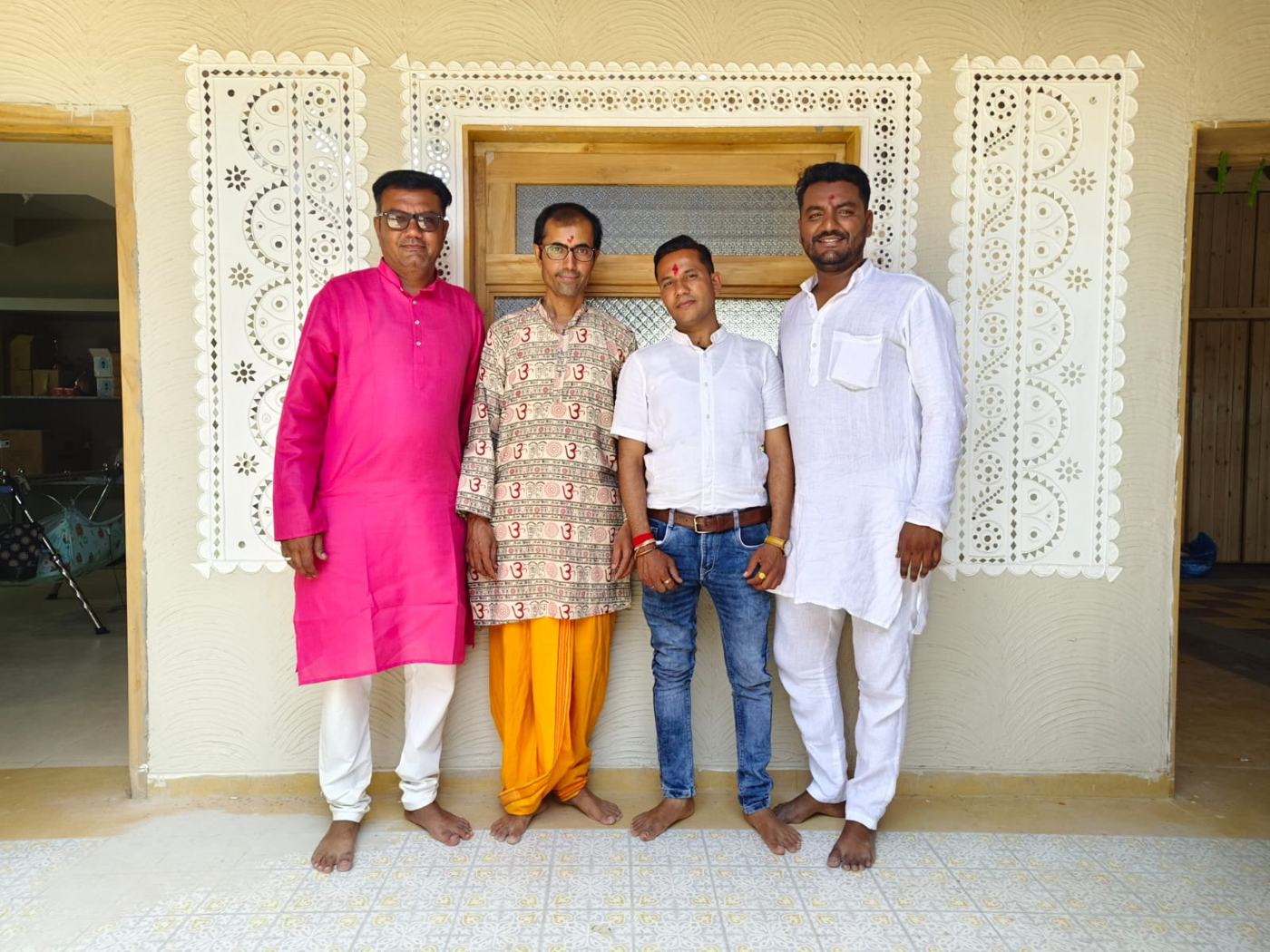 The Kutch ji Chhap team standing together in front of a carved window